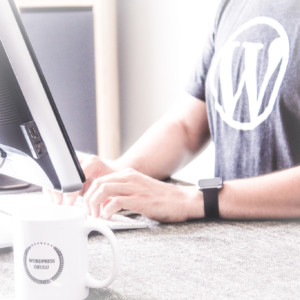 Photo of a website developer wearing a t-shirt with the WordPress logo on it