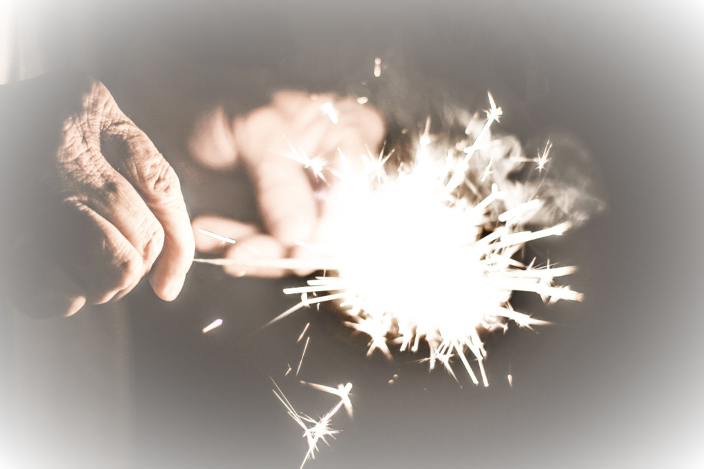 Photo of a sparkler in a person's hands.